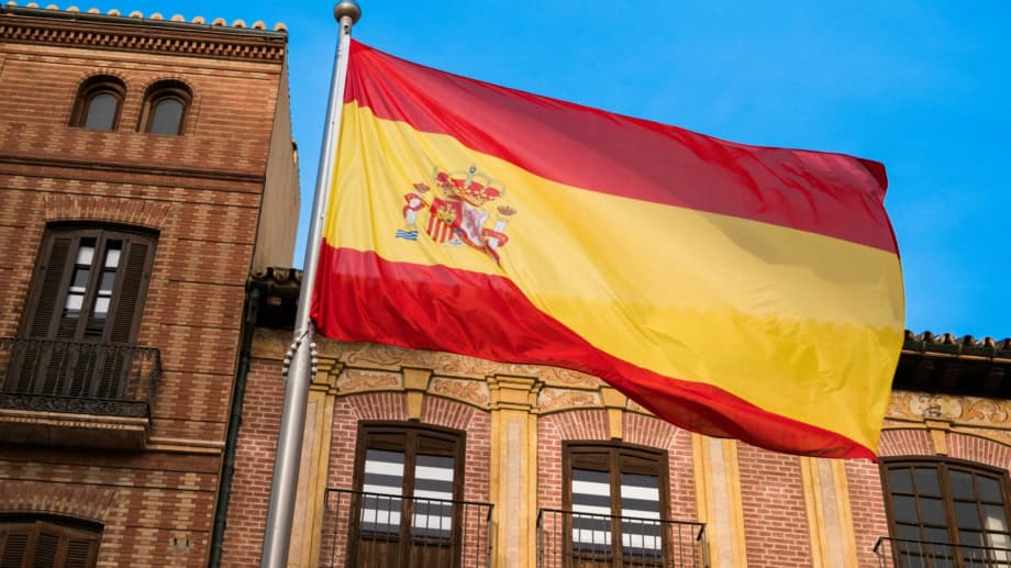 Spanische Flagge vor Gebäude als Symbol für die neuen E-Invoicing-Regeln und das VeriFactu-System in Spanien
